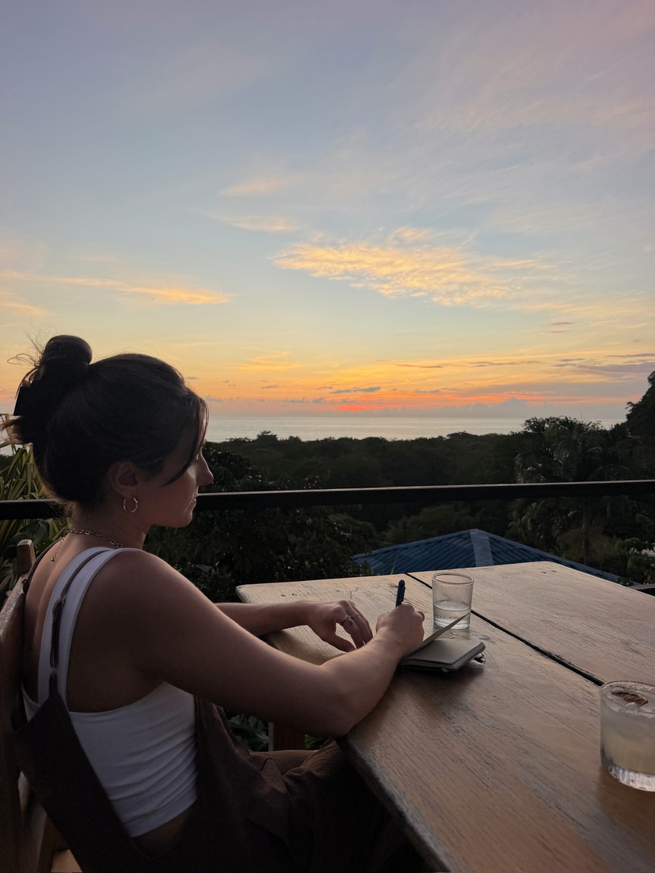 Dalia écrit dans un carnet au coucher du soleil